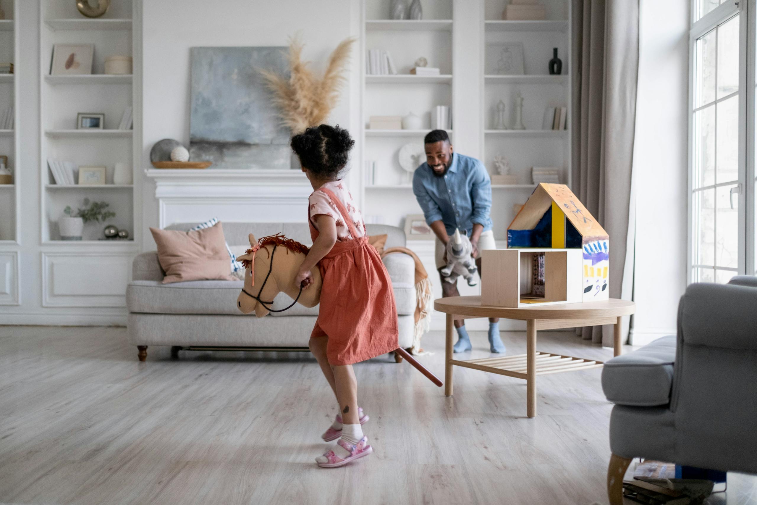 Father and daughter enjoying playful moment in stylish living room setting, highlighting family bonding.